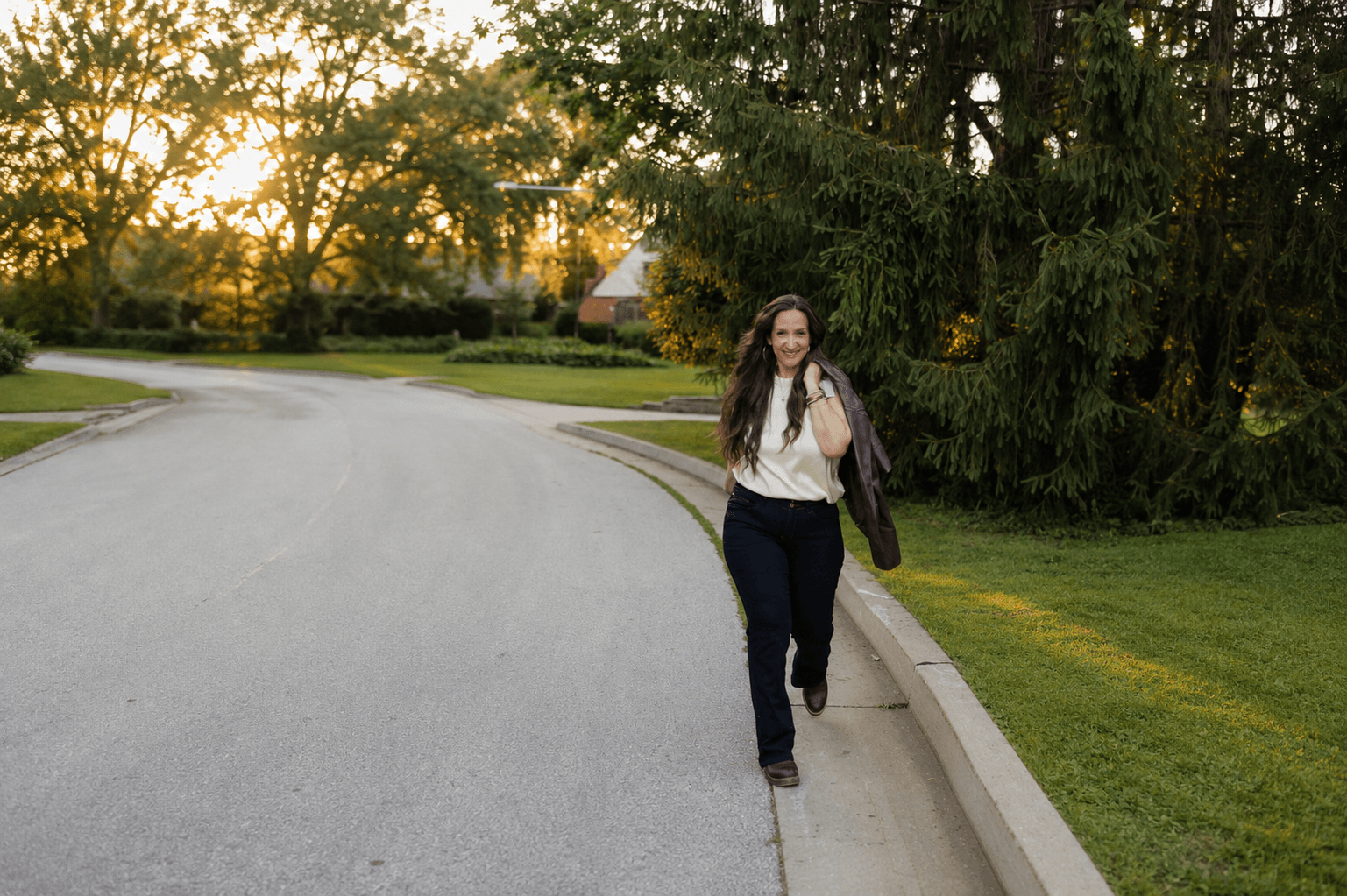 Marsha Kreho walking outdoors in golden-hour light.